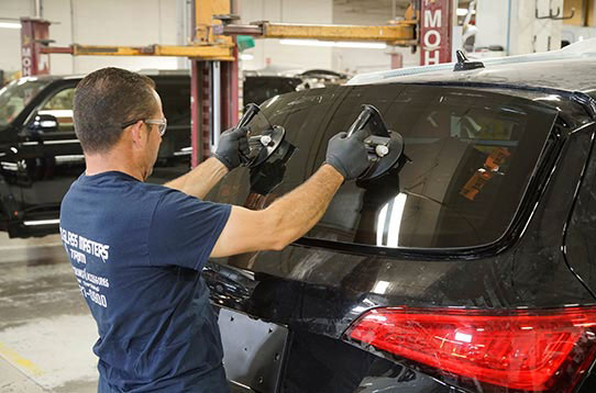 Technician replacing back glass on suv - auto glass repair - craigs collision